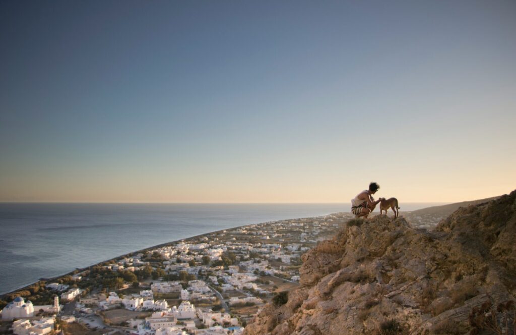 person with dog over santorini